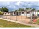 Cozy single-story home featuring an open parking area and fenced front yard at 1328 Waikiki Way, Tampa, FL 33619