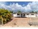Single-story home featuring a paver parking area and fenced yard with a palm tree at 1328 Waikiki Way, Tampa, FL 33619