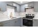 Modern kitchen with gray cabinets, white countertops, and stainless steel appliances at 1328 Waikiki Way, Tampa, FL 33619