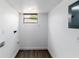 Bright laundry room with updated flooring, fresh white walls, and natural light from a small window at 1328 Waikiki Way, Tampa, FL 33619