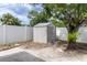Backyard featuring a modern storage shed with surrounding white privacy fence at 1328 Waikiki Way, Tampa, FL 33619