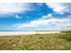 Expansive beach view featuring blue skies, white sand, and lush dune vegetation at 1340 Gulf Blvd # 16F, Clearwater, FL 33767