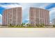 Two beachfront high-rise towers with balconies, set against a blue sky at 1340 Gulf Blvd # 16F, Clearwater, FL 33767