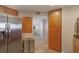 Kitchen view showcasing stainless steel fridge, wooden cabinets, and adjacent dining area at 1340 Gulf Blvd # 16F, Clearwater, FL 33767