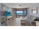 Light-filled living room with comfortable seating, a TV, and access to a balcony with stunning ocean views at 1340 Gulf Blvd # 16F, Clearwater, FL 33767