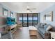 Bright living room with coastal decor, cozy seating, and sliding glass doors to a balcony overlooking the ocean at 1340 Gulf Blvd # 16F, Clearwater, FL 33767
