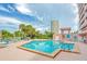 Enjoy the community pool with lounge seating, palm trees and shade from this condominium complex at 1340 Gulf Blvd # 16F, Clearwater, FL 33767