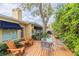 Charming backyard deck with outdoor seating, lush landscaping, and mature shade tree at 1370 Hill Dr, Largo, FL 33770