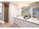 Bright bathroom with double sink vanity, floral wallpaper, and walk-in shower at 1370 Hill Dr, Largo, FL 33770
