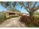 Inviting single-story home with a winding driveway, mature trees, and lush landscaping at 1370 Hill Dr, Largo, FL 33770
