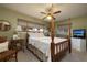 Comfortable primary bedroom with a four poster bed, ceiling fan, neutral carpet and window views at 1370 Hill Dr, Largo, FL 33770