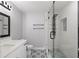 Remodeled bathroom featuring a walk-in shower with glass enclosure, modern vanity and fixtures and unique tile flooring design at 1586 Linwood Dr, Clearwater, FL 33755