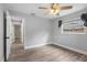 A simple bedroom with hardwood floors and light neutral paint with a window for natural light at 1586 Linwood Dr, Clearwater, FL 33755