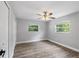 Bright bedroom features modern floors, two windows with backyard views, a ceiling fan, and spacious closet at 1586 Linwood Dr, Clearwater, FL 33755