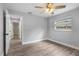 Bright bedroom with wood-look flooring, a ceiling fan, and a window providing natural light, creating a comfortable space at 1586 Linwood Dr, Clearwater, FL 33755