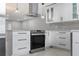 Modern kitchen with stainless steel stove, stylish range hood, and sleek white cabinetry at 1586 Linwood Dr, Clearwater, FL 33755