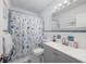 Bright bathroom features a nautical themed shower curtain, large mirror and blue tile accents at 1711 N Highland Ave, Clearwater, FL 33755