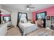 Bright bedroom features a ceiling fan, desk, and a comfy bed with decorative pillows and ample natural light at 1711 N Highland Ave, Clearwater, FL 33755