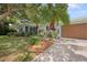 Charming home with a well-manicured lawn, mature landscaping, and an attached two-car garage at 1711 N Highland Ave, Clearwater, FL 33755