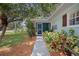 A charming home featuring a screened in front porch area with manicured landscaping at 1711 N Highland Ave, Clearwater, FL 33755