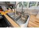 Close up on stainless steel kitchen sink with wood countertops and a stainless steel faucet at 1711 N Highland Ave, Clearwater, FL 33755