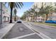 City street view with boutique storefronts and sidewalk and multiple parked vehicles under blue skies and scattered clouds at 1711 N Highland Ave, Clearwater, FL 33755