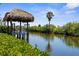Waterfront backyard with a tiki hut overlooking a canal with lush greenery and a serene water view at 18093 Ohara Dr, Port Charlotte, FL 33948