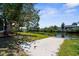 This home features a concrete walkway to the backyard and a tiki hut overlooking the canal at 18093 Ohara Dr, Port Charlotte, FL 33948