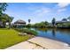 Backyard with a concrete boat launch, landscaping and a tiki hut by the canal at 18093 Ohara Dr, Port Charlotte, FL 33948
