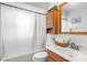 Bright bathroom featuring a combination tub and shower, wood cabinets and shelving at 18093 Ohara Dr, Port Charlotte, FL 33948