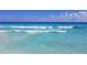Turquoise water and gentle waves along a white sand beach on a sunny day at 18093 Ohara Dr, Port Charlotte, FL 33948