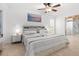 Bright bedroom with a ceiling fan, large windows, and comfortable bedding in neutral tones at 18093 Ohara Dr, Port Charlotte, FL 33948