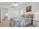 Bright bedroom with light neutral bedding, bedside tables, and an ocean-themed photograph at 18093 Ohara Dr, Port Charlotte, FL 33948