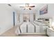 Bright bedroom with a ceiling fan, large windows, and comfortable bedding in neutral tones at 18093 Ohara Dr, Port Charlotte, FL 33948