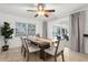 The dining room features a modern table, chandelier fan, and view to the lanai at 18093 Ohara Dr, Port Charlotte, FL 33948