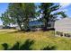 View of screened-in lanai, a storage shed and trees in the backyard at 18093 Ohara Dr, Port Charlotte, FL 33948