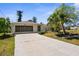 Charming single-story home featuring a screened garage, front yard trees, and a long private driveway at 18093 Ohara Dr, Port Charlotte, FL 33948