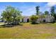 Home featuring mature trees, landscaping and a well-maintained lawn at 18093 Ohara Dr, Port Charlotte, FL 33948