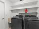 Neat laundry room featuring modern washer and dryer, sink, and ample shelving at 18093 Ohara Dr, Port Charlotte, FL 33948