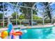 Lively screened pool featuring a dolphin statue, canal view, and assortment of colorful pool toys at 18093 Ohara Dr, Port Charlotte, FL 33948