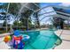 Beautiful pool area featuring canal views, tropical greenery and an assortment of pool toys for enjoyment at 18093 Ohara Dr, Port Charlotte, FL 33948