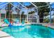 Sparkling screened-in pool with clear water, tropical landscaping, and fun inflatable toys for Gathering enjoyment at 18093 Ohara Dr, Port Charlotte, FL 33948