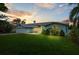 Exterior view of house at sunset showing the lawn and front porch at 1825 Welland Dr, Clearwater, FL 33756