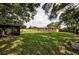 Large fenced backyard featuring mature trees and a fire pit at 1893 Harding St, Clearwater, FL 33765