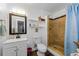 Bright bathroom featuring a tiled shower, white vanity, and decorative shelving at 1893 Harding St, Clearwater, FL 33765