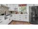 Bright and airy kitchen featuring white cabinets, a stainless steel sink, and stylish backsplash at 1893 Harding St, Clearwater, FL 33765