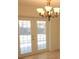 Beautiful French doors with a chandelier above create a seamless connection to the outdoor, bringing natural light and charm at 201 Faithway Dr, Seffner, FL 33584