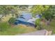 Aerial view of a blue house, showcasing the expansive yard, pool, and mature trees at 23067 Brighton Pl, Land O Lakes, FL 34639