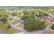 An aerial view of a neighborhood featuring lush trees, a pond, and well-maintained homes at 23067 Brighton Pl, Land O Lakes, FL 34639