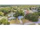 An overhead view of a neighborhood featuring lush trees, a pond, and well-maintained homes at 23067 Brighton Pl, Land O Lakes, FL 34639